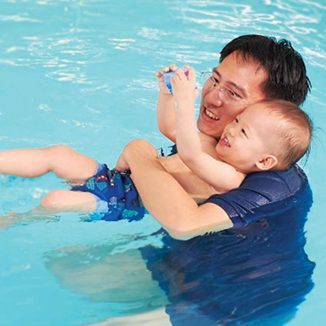 Fathers holding his baby in the water